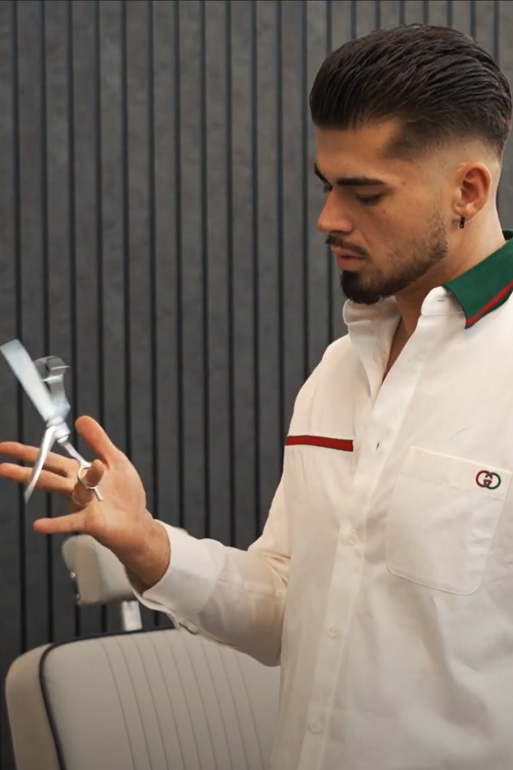 Freezy’s Hairstyle & Barber – Friseur hält Haarschere in den Händen für präzise Haarschnitt-Dienstleistungen